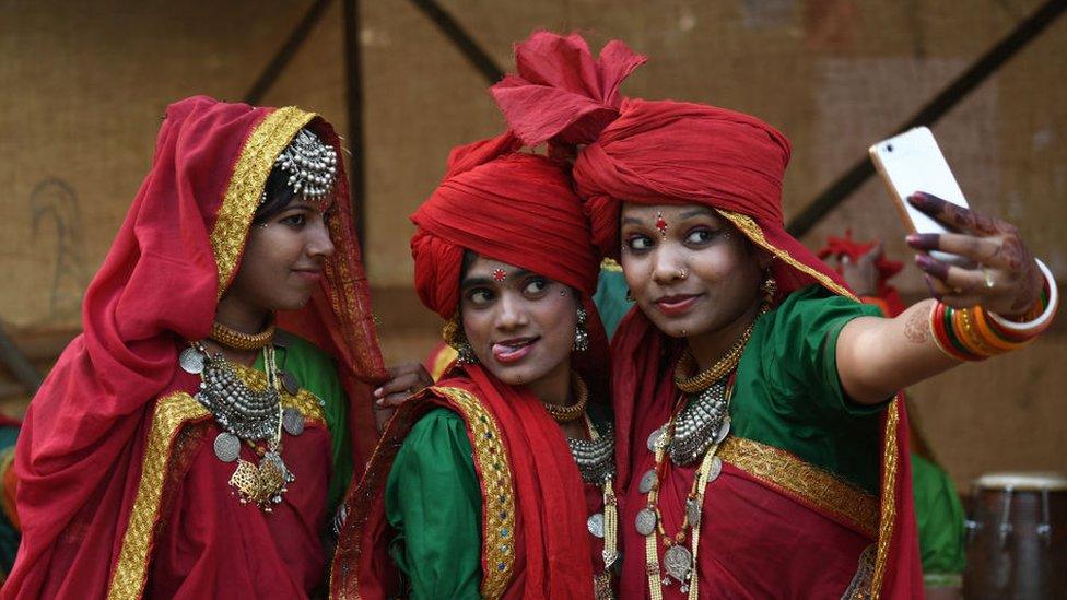 Performers from central India of Madhya Pradesh take a selfie.