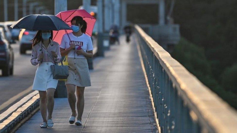 Women walking across bridge in Wuhan city