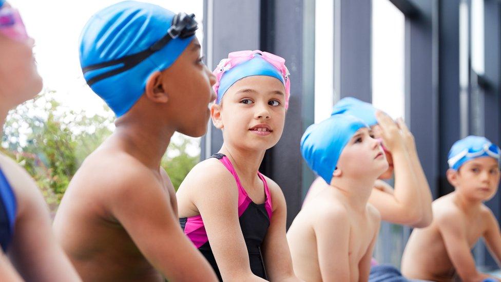 kids-wearing-swimming-costumes-and-caps