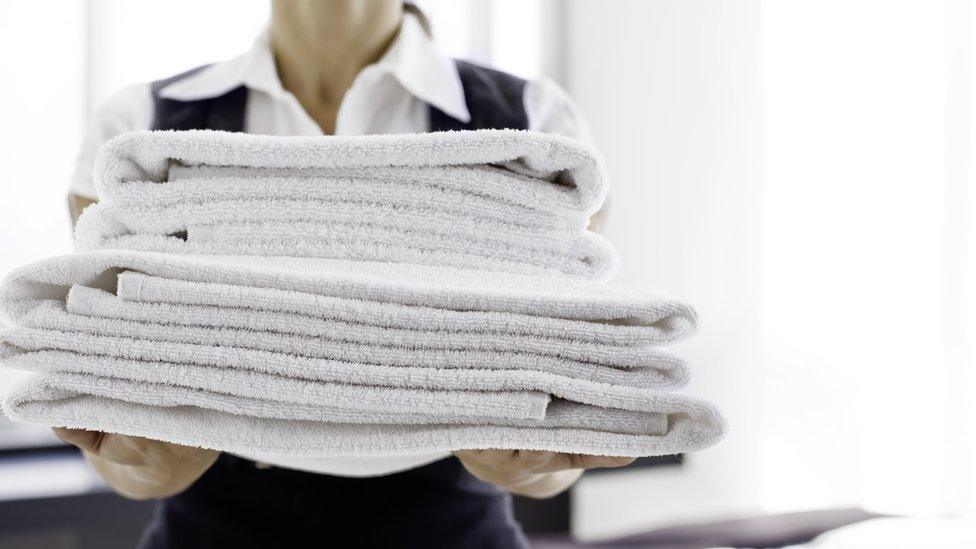 Stock image of a maid holding towels