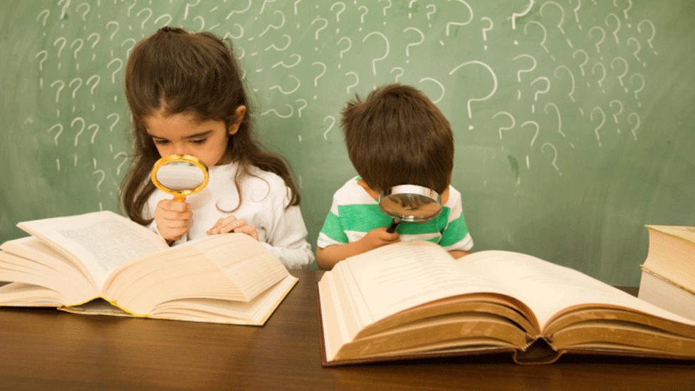 Children looking for clues with magnifying glass