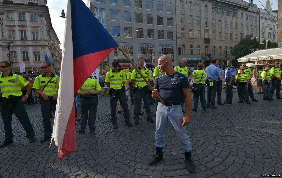 A far-right activist holds Czech national flag during an anti-immigrants rally on 18 June 2015 in Prague at a protest against a proposed mandatory migrants quota by the European Commission.