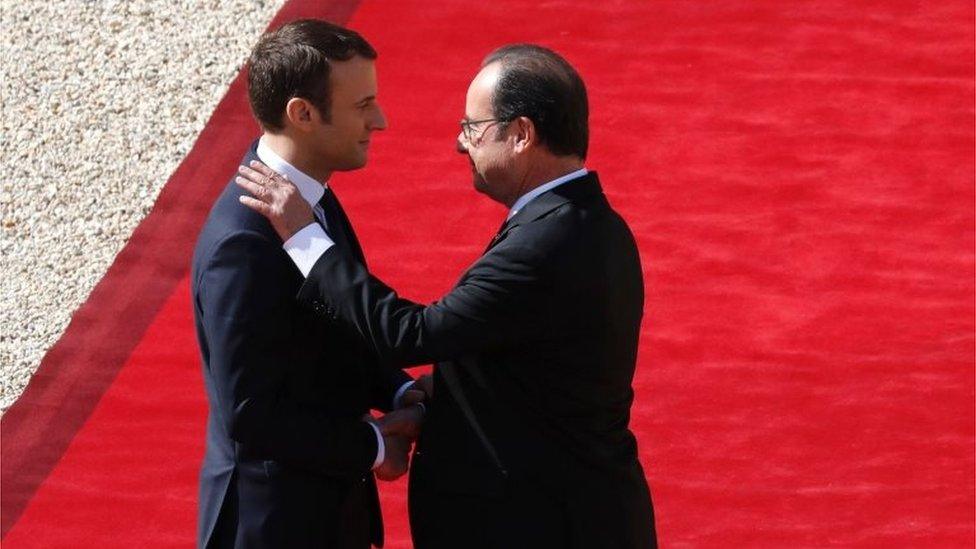 French outgoing President Francois Hollande (R) is escorted by his successor Emmanuel Macron as he leaves the Elysee presidential Palace at the end of their handover ceremony and prior to Macron's formal inauguration as French President on 14 May 2017 in Paris