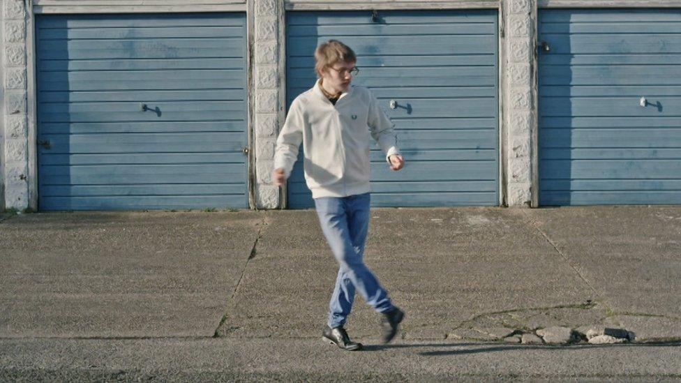 Anthony dancing in front of garages