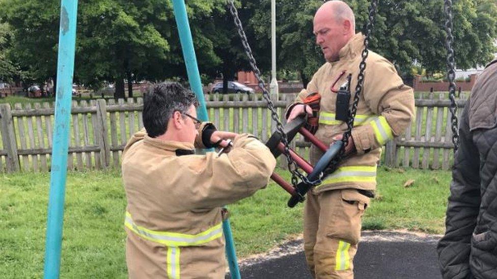 Firefighters putting swing back together