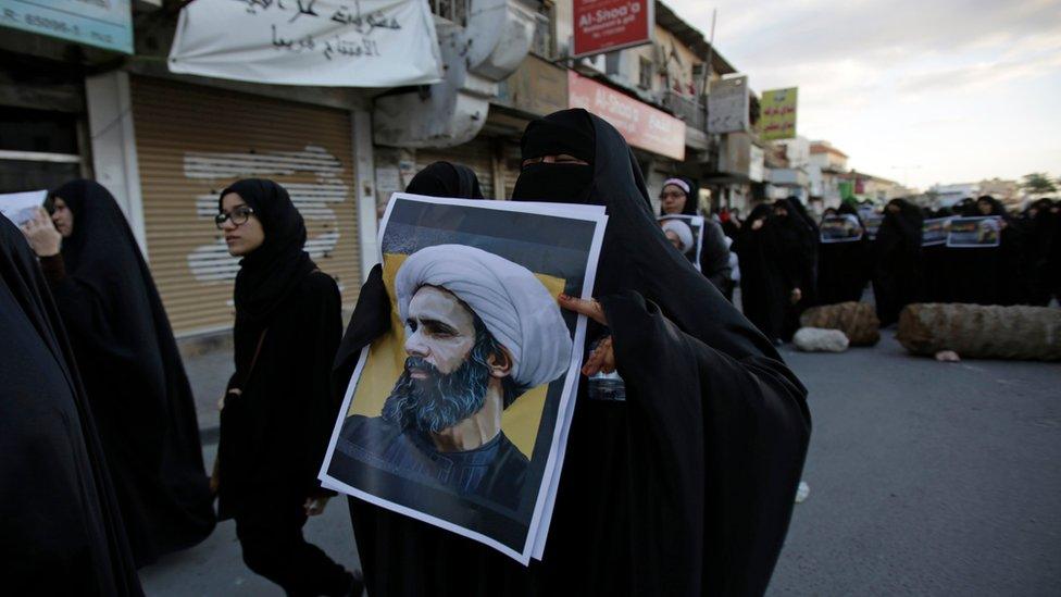 A Bahraini protester holds a picture of Saudi Shiite cleric Sheikh Nimr al-Nimr during a rally denouncing his execution by Saudi Arabia, Sunday, Jan. 3, 2016, in Daih, Bahrain.