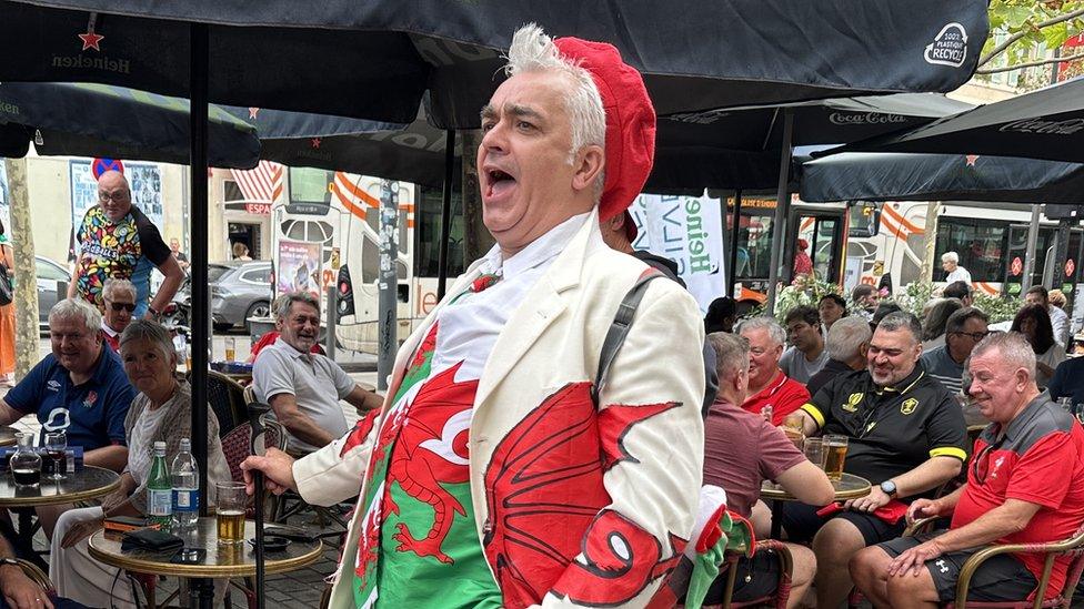 Wales fans in Marseilles are quietly confident of a win. Pictured is a man wearing a coat with a Welsh dragon printed across it