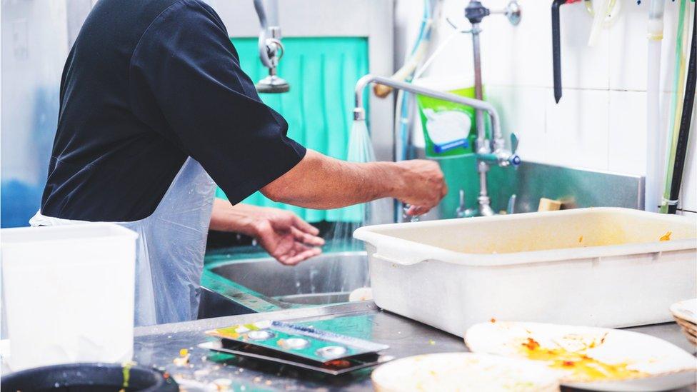 Worker washing dishes