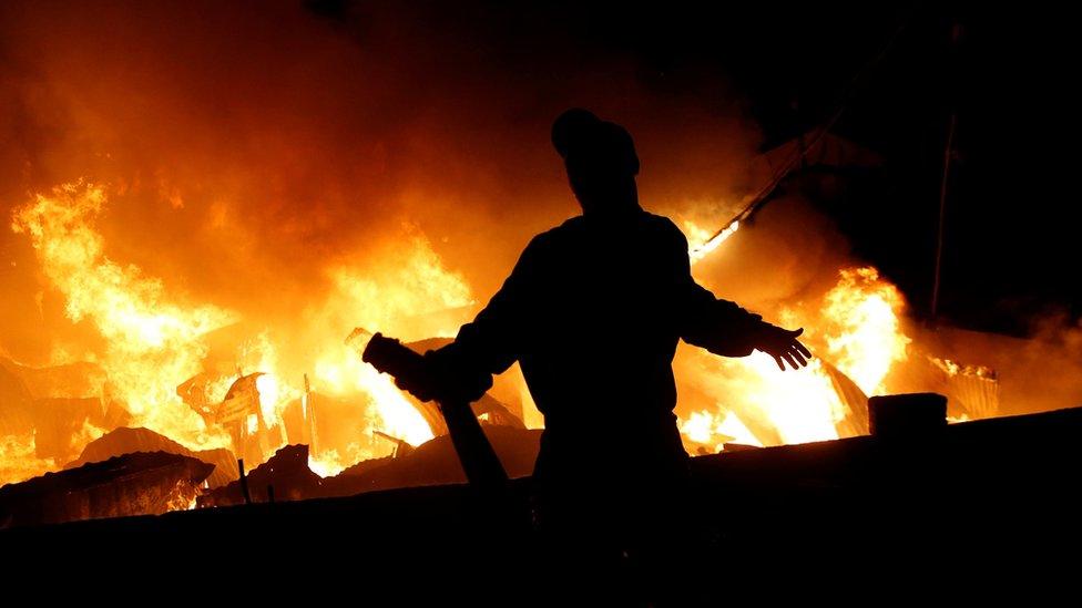 A resident reacts after running out of water as they attempt to extinguish a fire that broke out at the Kijiji slum in Southlands estate of Nairobi, Kenya January 28, 2018