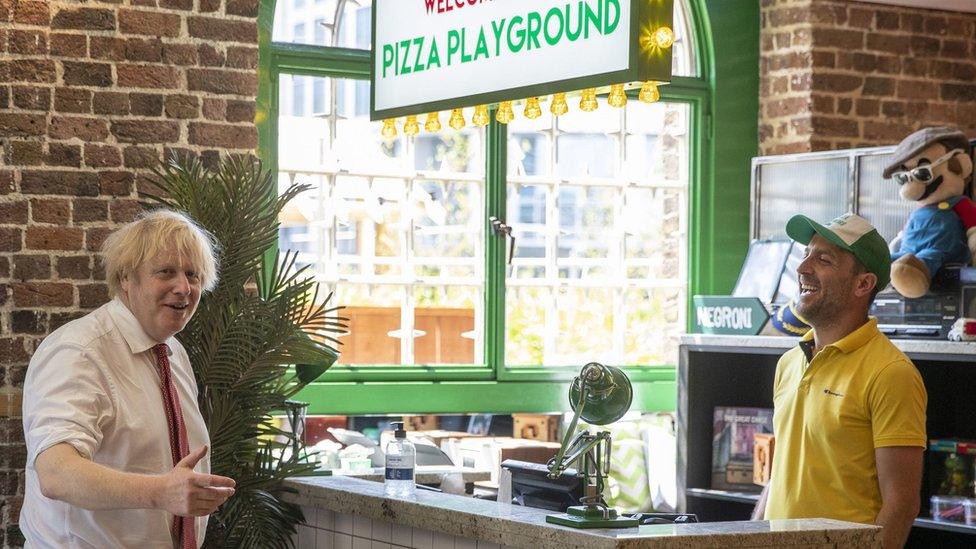 Boris Johnson and a member of staff at a pizza restaurant