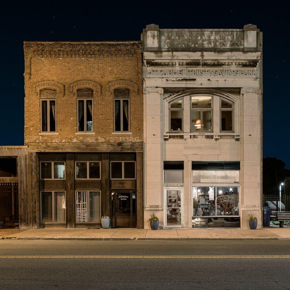 A night view of two solitary buildings on an empty street