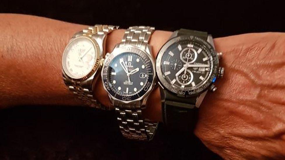 Close up of a man wrist wearing three luxury watches