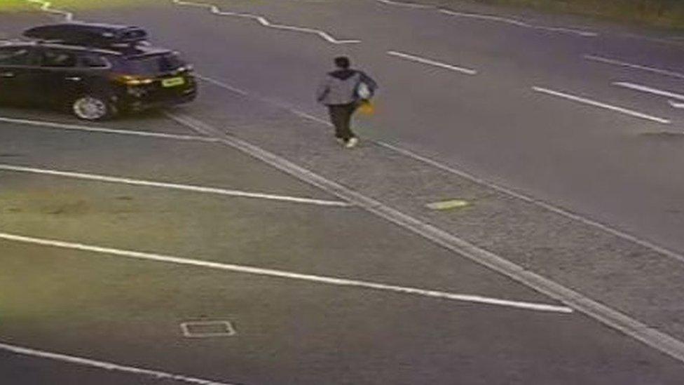 A man walking along Yarmouth Road carrying what appears to be a rucksack over one shoulder and an orange bag – possibly a Sainsbury’s carrier bag