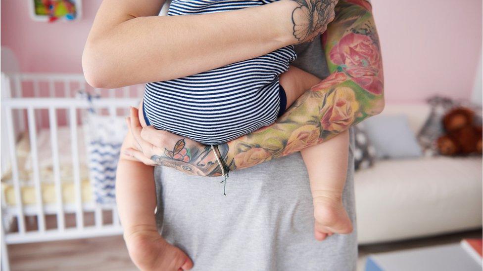 A woman holds her baby