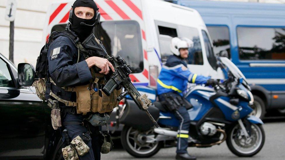 A masked and armed special forces member secures the street outside the courthouse during the departure of Paris attacks suspect Salah Abdeslam in Paris, France (20 May 2016