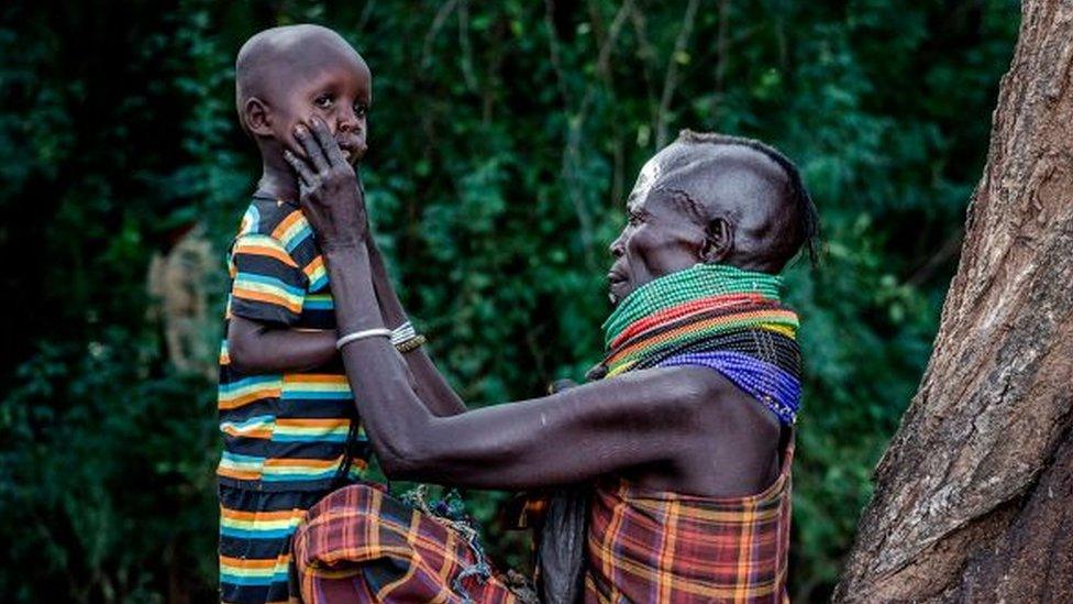 Mother holds the face of her son