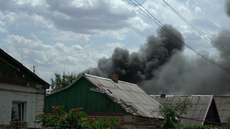 Smoke rising near homes in Donbas