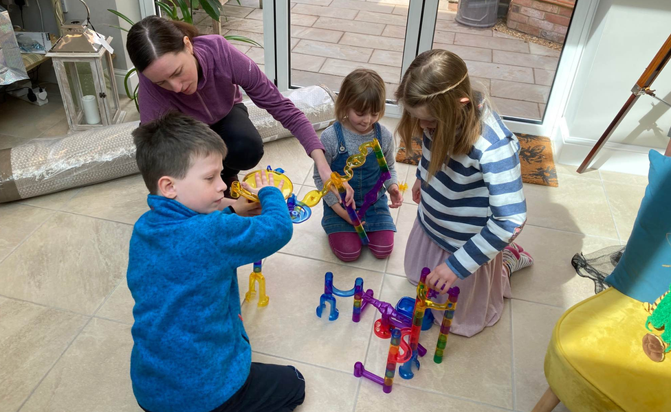 Anna Kolomiichuk and her son playing a game with North Norfolk MP Duncan Baker's daughters