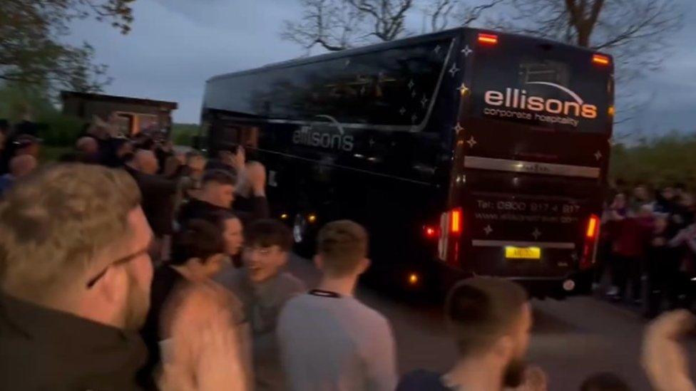 Fans clapping team bus