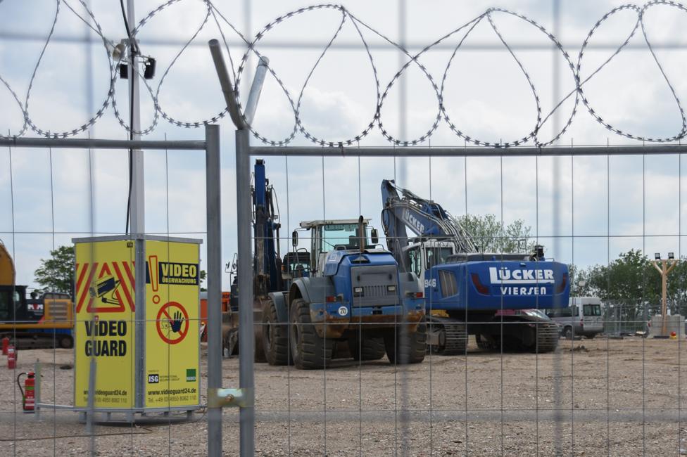 Diggers behind razor wire