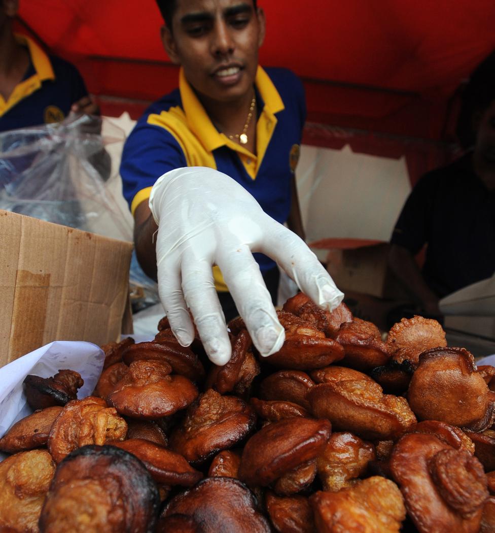 A Sri Lankan confectionary seller displays the traditional Sinhala Tamil New Year oil cake snack kevum in Colombo