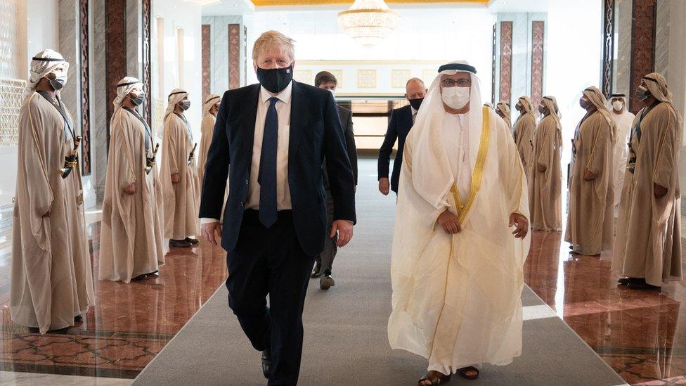 The prime minister inspects a guard of honour after landing at Abu Dhabi airport