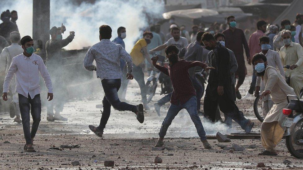 Supporters of Islamic political party Tehreek-e-Labbaik Pakistan (TLP), throw stones at the police during a protest to demand the release of their leader Saad Hussain Rizvi