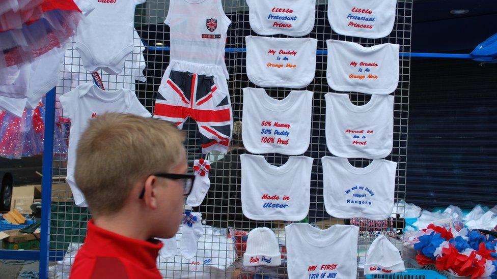 Twelfth of July merchandise stall with boy walking past