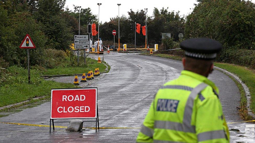 A policeman looks towards the scene of the crash