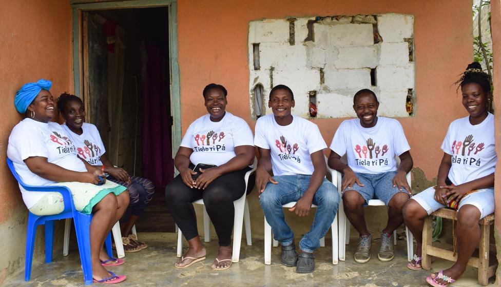 Volunteers for Tiela Ri Pá sit on the porch of a house in Palenque