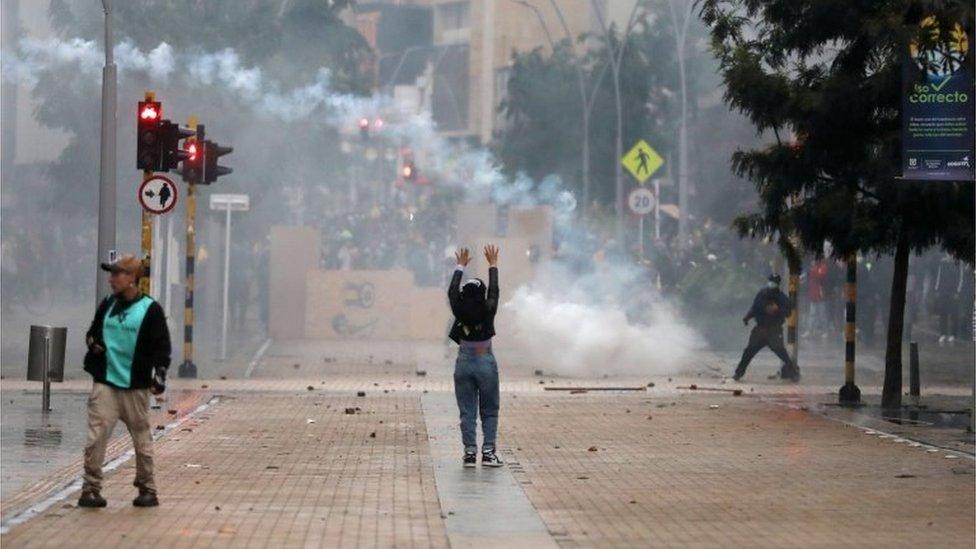 A protester raises her arms during a protest against the tax reform of President Ivan Duque's government in Bogota, Colombia, May 1, 2021.