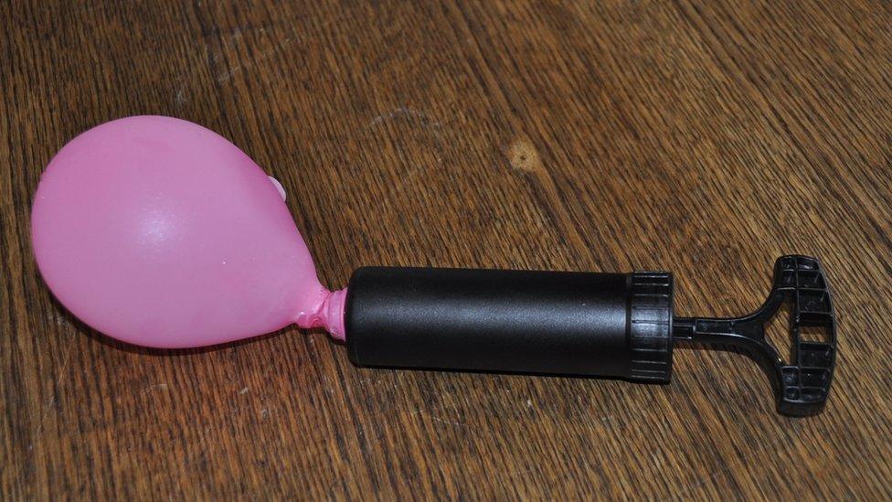 An bicycle pump inflating a balloon