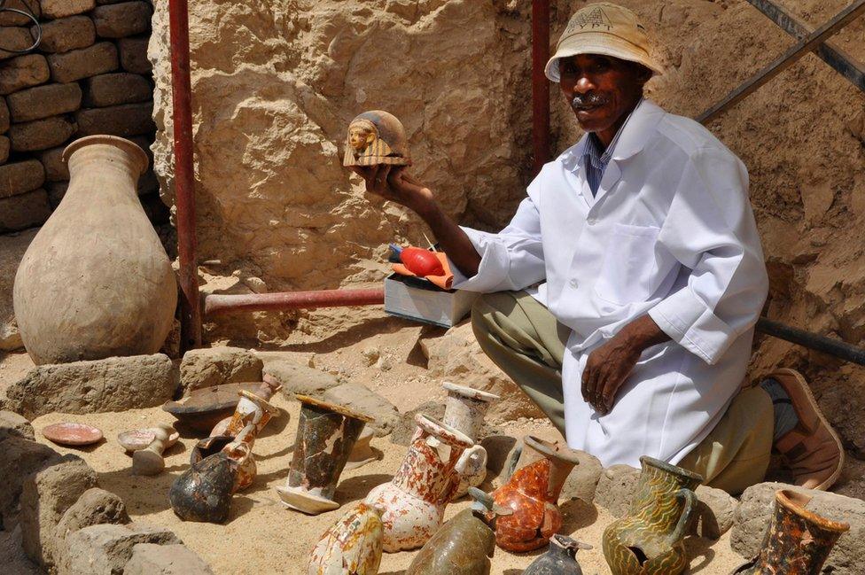 man holding pottery surrounded by jugs