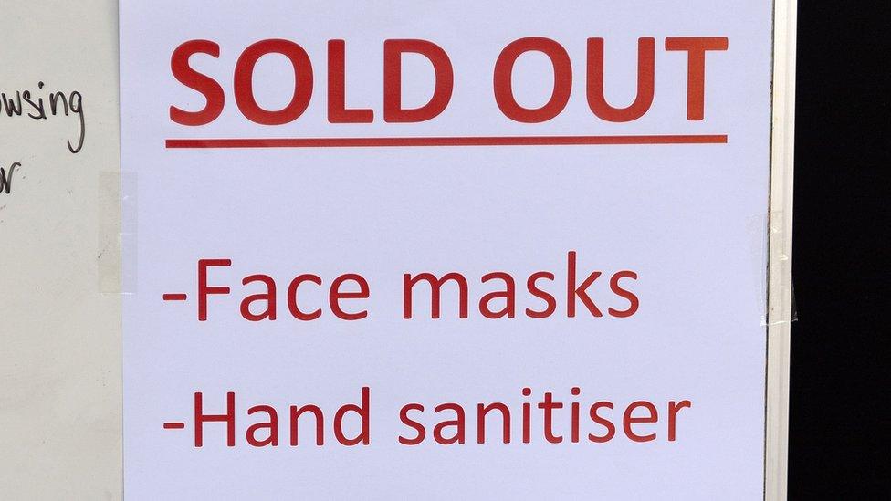 Sign in shop window saying that face masks and hand sanitiser have sold out