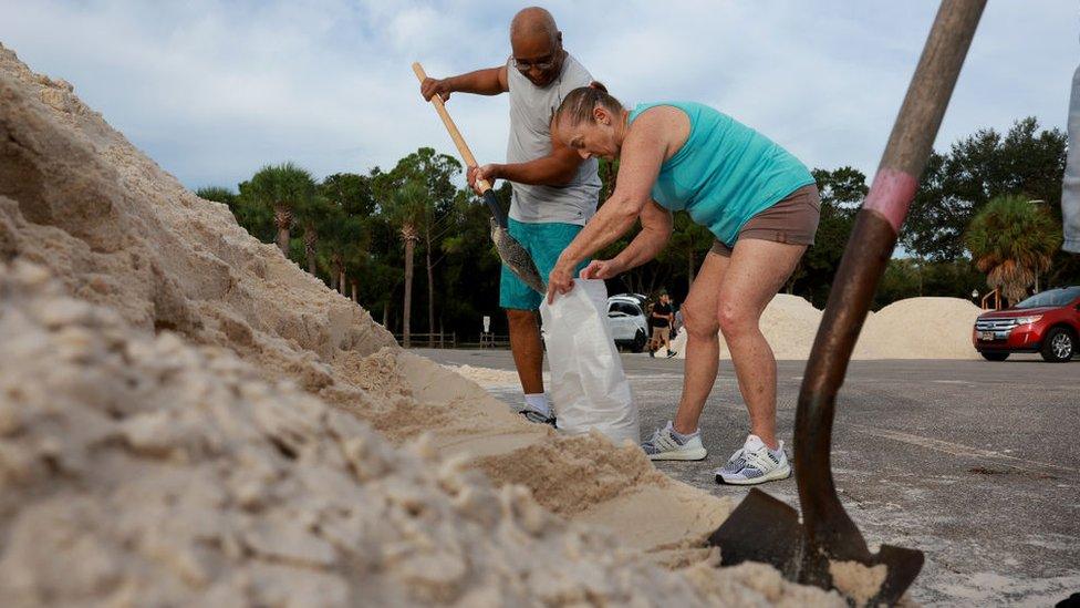 Anthonio Floyd (L) and Vinell Chambers fill sandbags at the Helen S. Howarth Community Park ahead of the possible arrival of Hurricane Idalia on August 29, 2023 in Pinellas Park, Florida