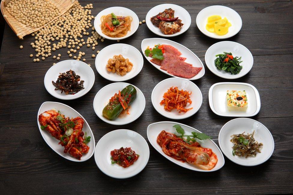 A table with lots of small Korean dishes