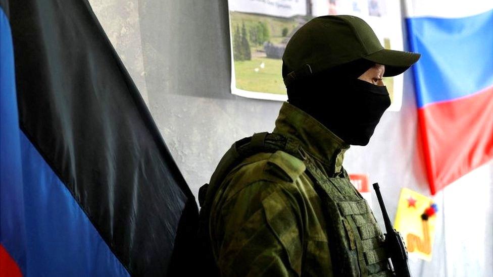 A service member of the self-proclaimed Donetsk People"s Republic stands guard at a polling station