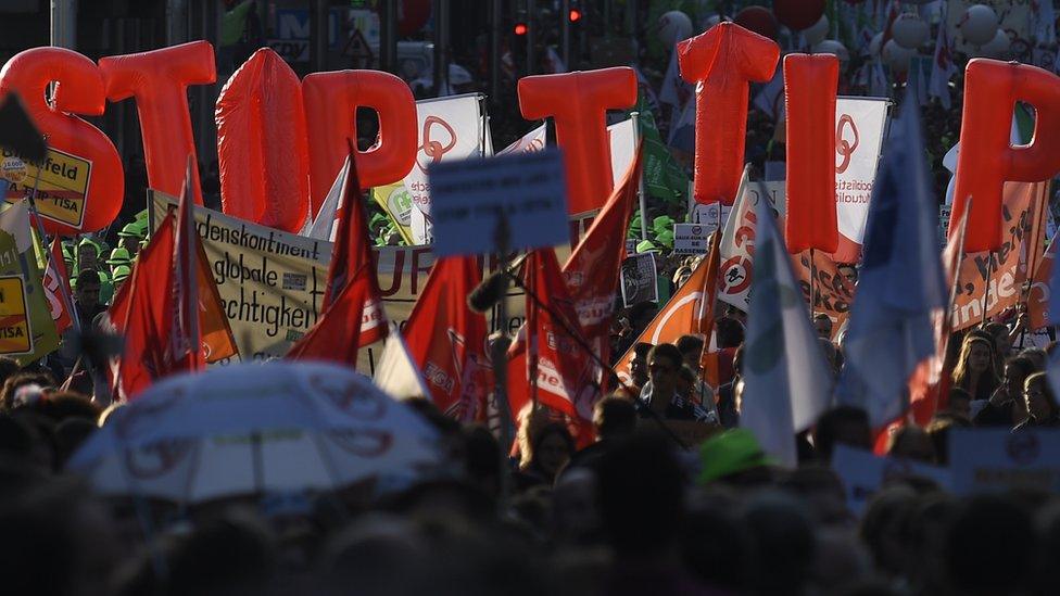 People hold balloons reading 'Stop TTIP' during a demonstration outside the European Union headquarters in Brussels, on September 20, 2016