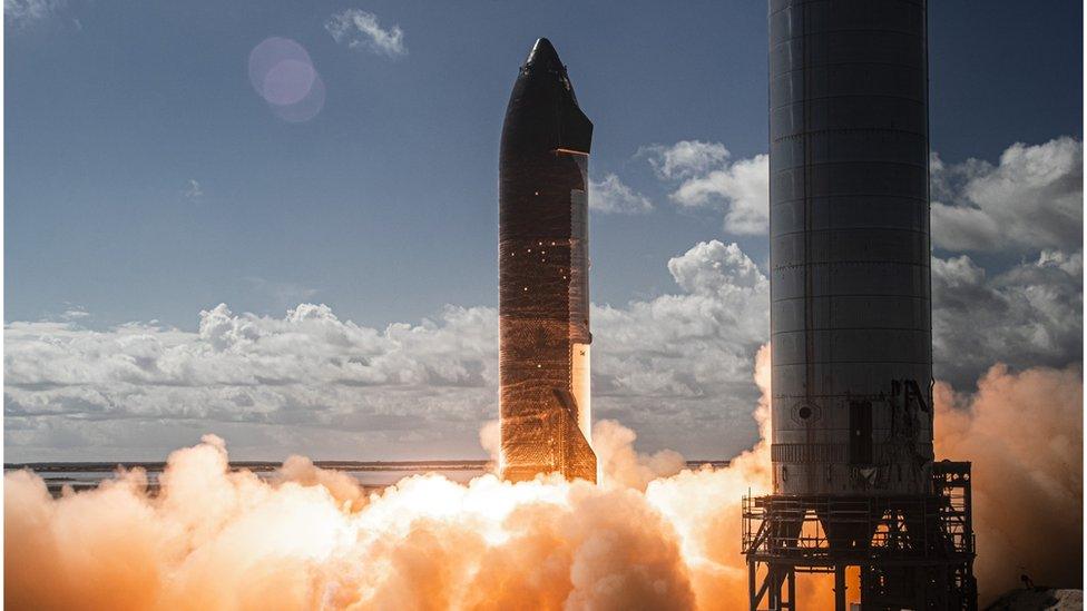 The first test-firing of six Raptor engines on the company's Starship SN20 rocket prototype on Nov. 12, 2021 at the Starbase facility in near Boca Chica Village in South Texas. A Starship Super Heavy booster stands at right.