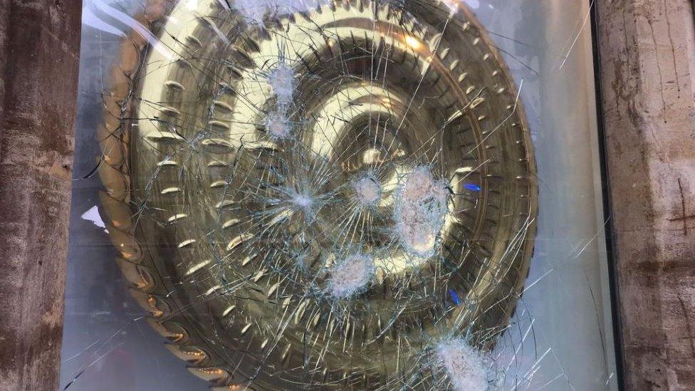 Glass with cracks and shattered glass after hammer attack