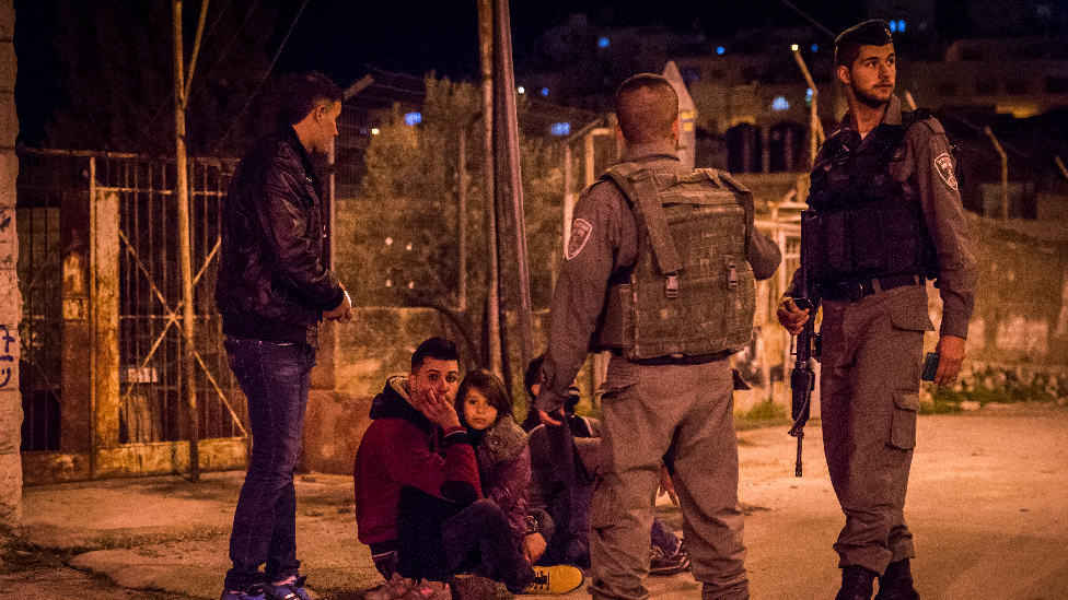 Soldiers surrounding people on the street in Hebron