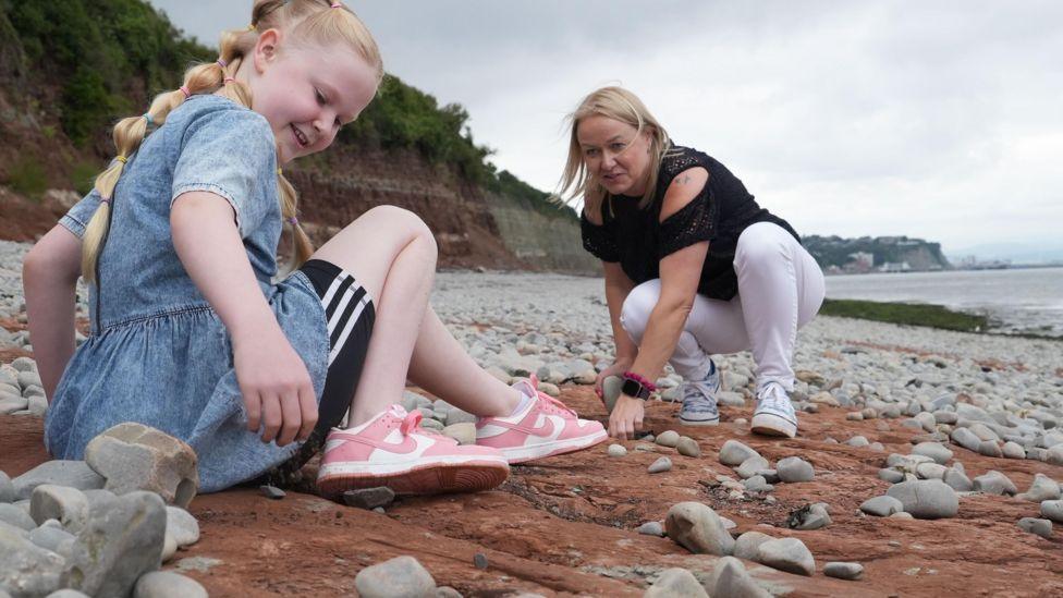 Tegan and her mum on the beach with the discovery 