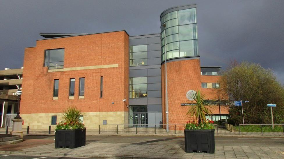 Exterior of the red-brick Hull Magistrates Court, which has a glass central block and a glazed tower at the top