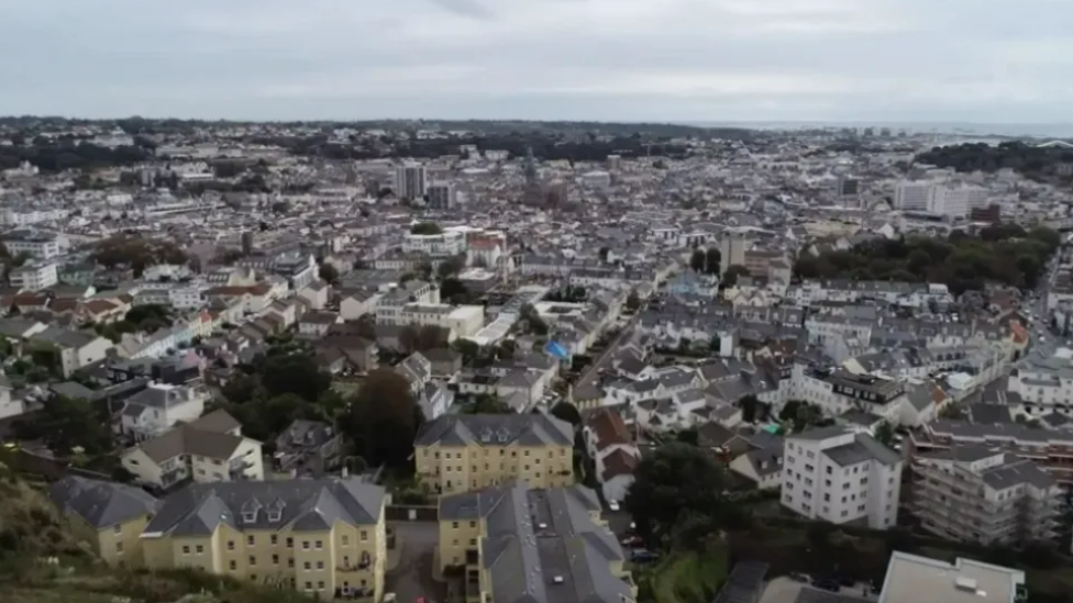 An aerial shot of St Helier showing hundreds of buildings and the coast in the distance