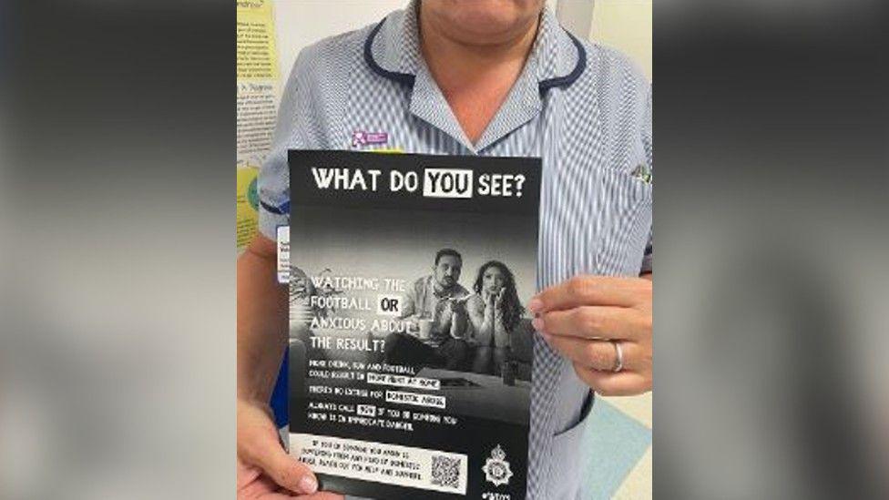 A support worker holding a domestic abuse sign