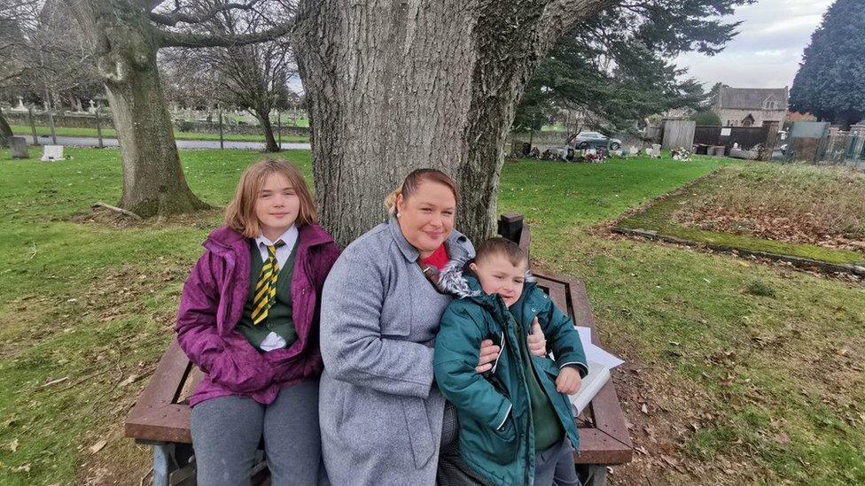 Katie and her children in a graveyard