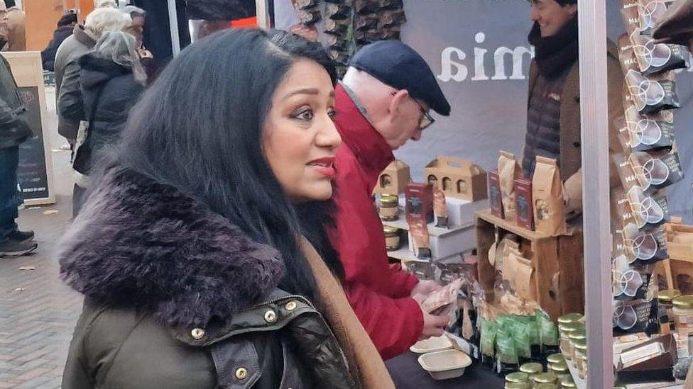 Pinder Chauhan talking to someone at a market