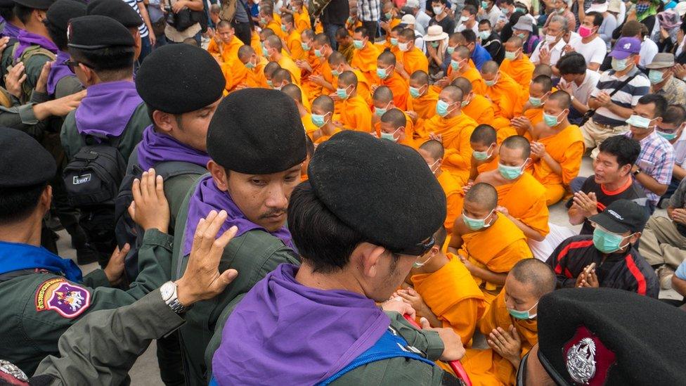 Police and temple-followers face off outside the temple