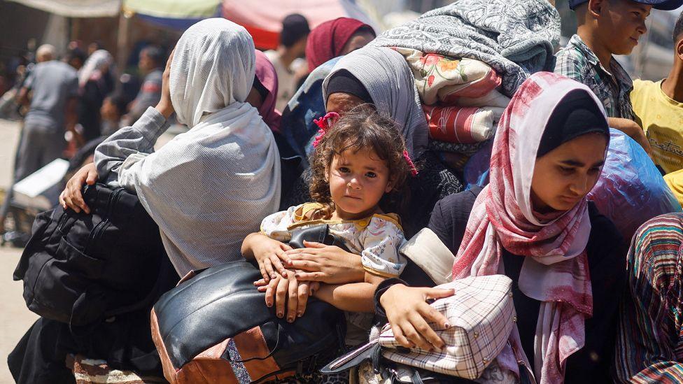 Palestinians leave Khan Younis on a vehicle loaded with belongings