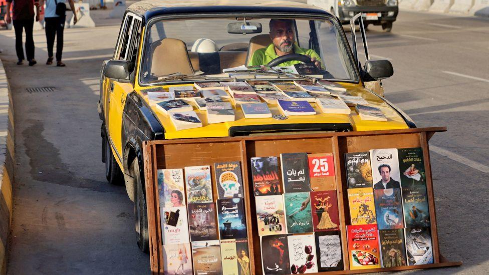 A man sitting in his mobile library known as the "Taxi Book” in Alexandria, Egypt – Monday 3 June 2024